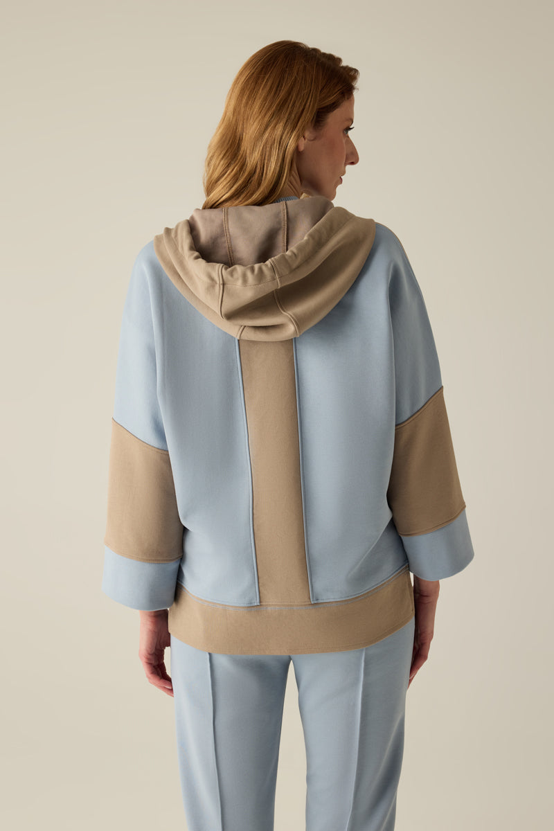 Hochwertige Damen-Sweatshirtjacke mit Kapuze und Doppel-Kordel, modernem Materialmix in Caramel & Blau und überschnittenen Schultern. Der verlängerte Rücken sorgt für eine lässige Silhouette, während die Pailletten-Stickerei am Saum edle Akzente setzt...