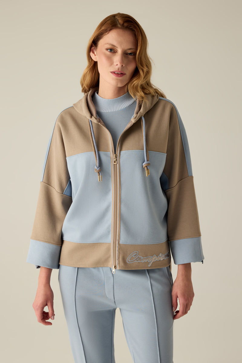 Hochwertige Damen-Sweatshirtjacke mit Kapuze und Doppel-Kordel, modernem Materialmix in Caramel & Blau und überschnittenen Schultern. Der verlängerte Rücken sorgt für eine lässige Silhouette, während die Pailletten-Stickerei am Saum edle Akzente setzt...
